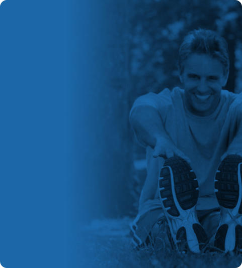 A blue banner with an overlayed photo on the right half. The photo shows a middle-age man sitting outside in a park. He is dressed in exercise clothing and is smiling as he stretches to touch his toes.